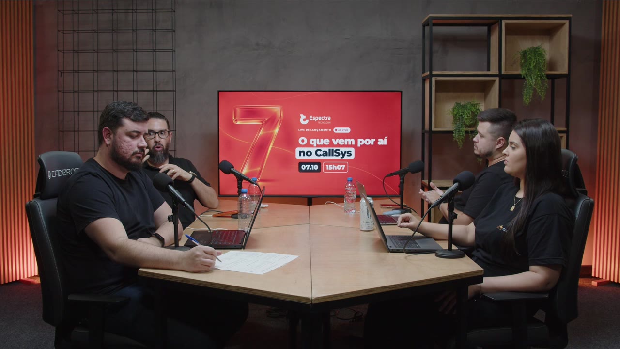 A mesa da live O 7 do CallSys, com o time da Espectra e o telão do 7